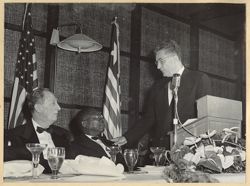 Ohio Governor Frank J. Lausche stands at podium as he speaks to President William V. S Tubamn and Lee R. Jackson
