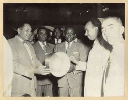 President William V. S. Tubman stands with men on tour of pan factory