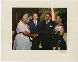 President William V. S. Tubman shakes hands with Mary Bethune Mcleod while Vice-President Simpson looks on