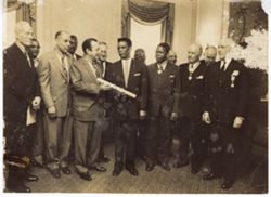 Ambassador Clarence Simpson holds award ceremony with men wearing Humane Order of Aftican Redemption decoration