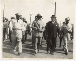 President William V. S. Tubman and others in military and business dress walk together