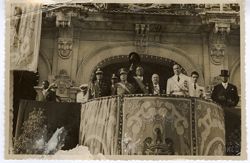 President William V. S. Tubman waves top hat on balcony surrounded by military officials