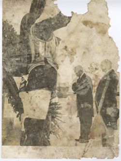 President William V. S. Tubman stands with official outdoors in front of wreath