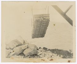 A crane lifts a large basket near the waterfront