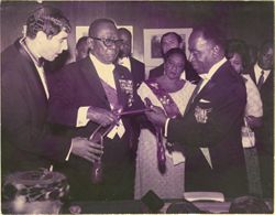 President Tubman listens as companion speaks about art object