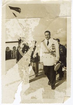 President William V. S. Tubman in formal attire walks with official wearing the Humane Order of African Redemption decoration