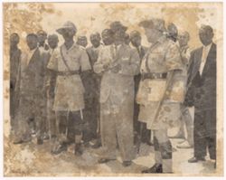 President William V. S. Tubman talks with an official while surrounded by other dignitaries