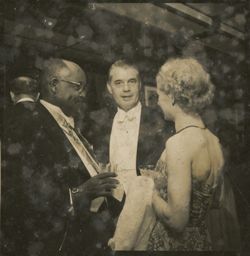 Guests in formal attire chat during a reception