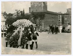 President William V. S. Tubman walk with officials behind military personnel carrying large wreath