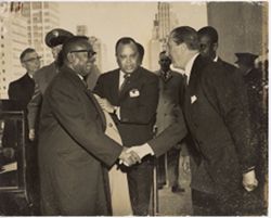 Exiting a limo, President William V. S. Tubman steps into a friendly handshake