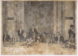 President Tubman confers with man during formal dinner