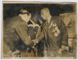 Dignitary bows as he shakes hands with President Tubman