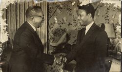 President William V. S. Tubman smiles while shaking hands with unidentifed man