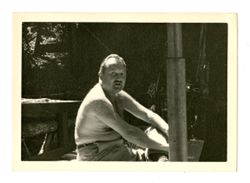 Jack Howard sitting shirtless outdoors