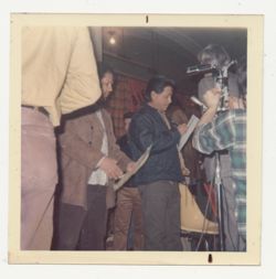 Cesar Chavez with paper in front of microphone