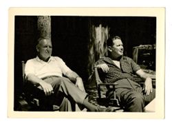 Men sitting outside of a cabin
