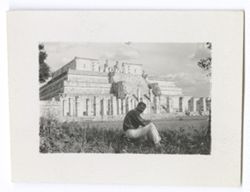Item 1012. Tissé seated on grass in shade. Temple of the Warriors in background.