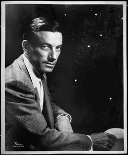 Publicity photo of Hoagy Carmichael with hat in hand and "stars" in the background.