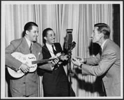 Hoagy Carmichael and two unidentified musicians performing around a microphone labeled "Mutual," ca. 1944-45.