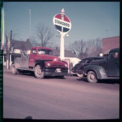 Standard Oil sign with cars, outside Ogle Garage