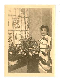Woman in kimono posing next to flowers