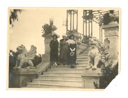 Three woman standing on ornate steps.