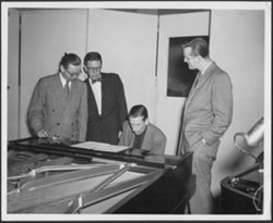 Hoagy Carmichael at the piano with Cy Walter, Joe Ripley, and Charles Wilkes looking on.