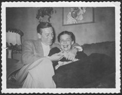 Hoagy Carmichael and Ruth Carmichael sitting on a sofa looking at her ring.