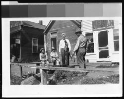 Four males at water pump in front of store