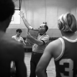 IU South Bend men's basketball coach demonstrates skills to team, 1970s
