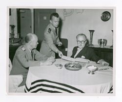 Roy Howard sitting with other men