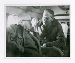 Roy Howard and man talking on plane
