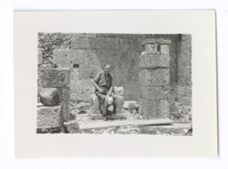 Item 1050. Seated on stone figure of jaguar at lower Temple of the Jaguars.