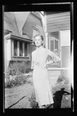 Martha Carmichael standing in front of a house.