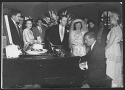 Hoagy Carmichael playing piano at the wedding of an unidentified couple.