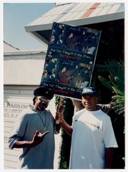 Michael Nixon and Russell Simmons holding promotional poster for Jay-Z