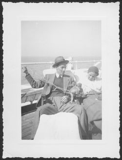 Hoagy Carmichael with Ruth Carmichael on the deck of a ship with a monkey on his lap.