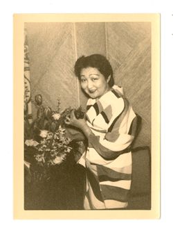 Woman in kimono posing next to flower