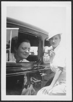 Martha Carmichael standing next to a car with an unidentified young woman.