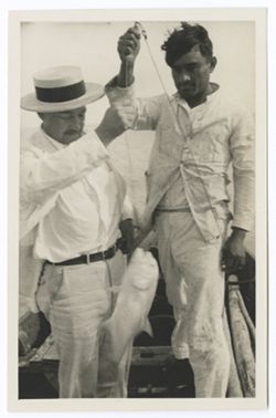 Item 0546. Close-up of Kimbrough, left, and unidentified man standing in a boat holding a large fish on a line.