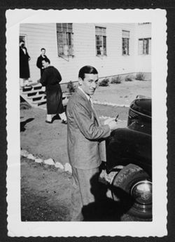 Hoagy Carmichael standing next to an automobile.