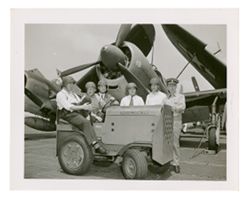 Roy W. Howard and other men next to military airplane