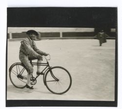 Item 0609. Liceaga in arena, riding a bicycle.