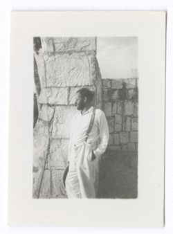 Item 1057. - 1057a. Similar shots of Eisenstein leaning against a carved column at the Colonnade of the Temple of the Warriors. Portion of high wall visible in background.