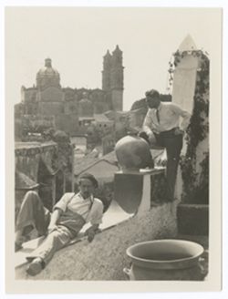Item 0528. Dr. Best-Maugard and Alexandrov on balustrade of building overlooking a city. Large church in background.