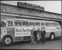Hoagy Carmichael at an Atlanta bus terminal, posing beside a bus, during the "Stars over Georgia" tour.