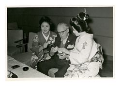 Roy Howard sitting with two women