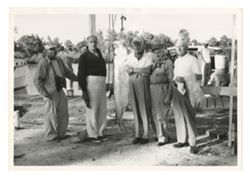 Roy Howard with company standing with fish